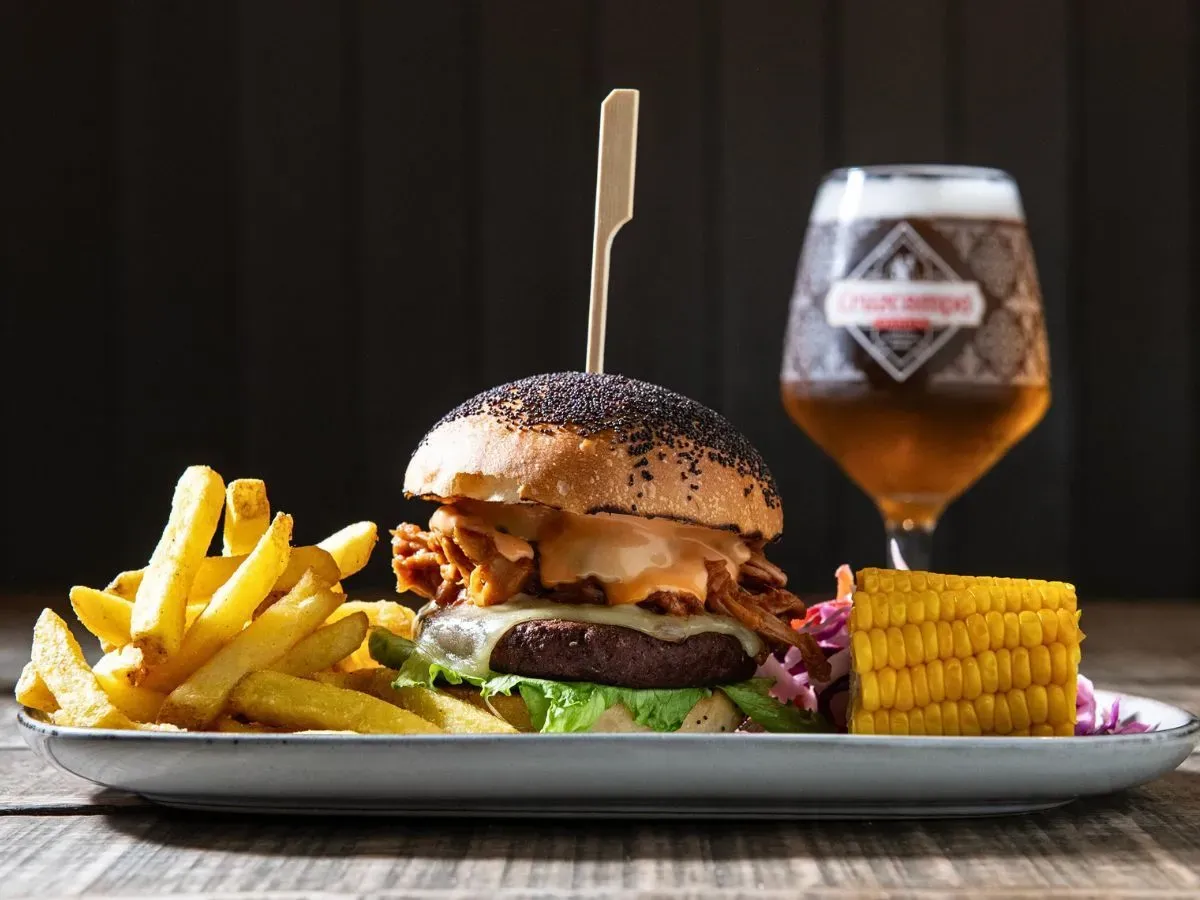 Smash burger with fries, corn on the cob and a glass of Cruzcampo